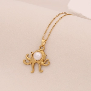 Macro detail of golden octopus pendant necklace with a central white pearl insert