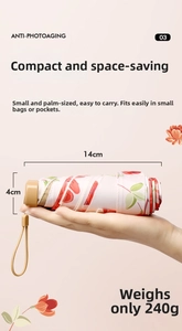 Compact 14cm sun umbrella featuring elegant red floral patterns on a white canopy