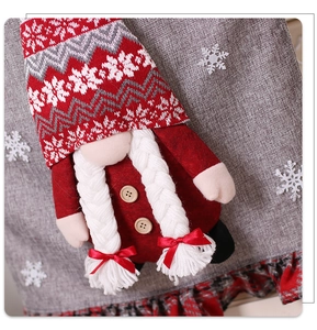 Detail of red Christmas gnome chair cover featuring a knitted hat and white braids