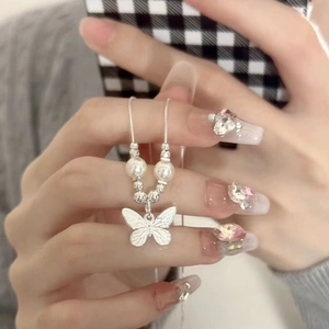 Close-up of double-layer butterfly pendant necklace with pearls and silver chain detail