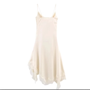 Elegant satin and lace camisole dress in apricot with asymmetrical hem on white background