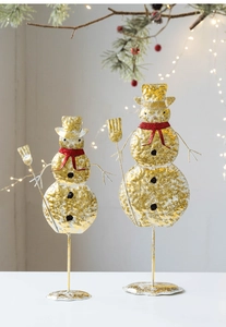 Detail of two-piece golden metal snowman set with hammered texture and red scarf accents