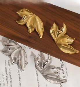 Detailed view of high polish gold and silver leaf earrings with PVD plating