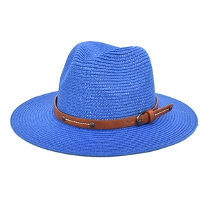 Detail of royal blue straw Panama hat featuring a brown leather belt with metal buckles