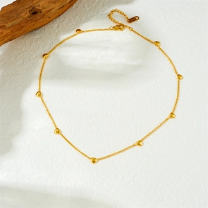 Minimalist gold-plated stainless steel necklace with 3D heart charms on a wood prop