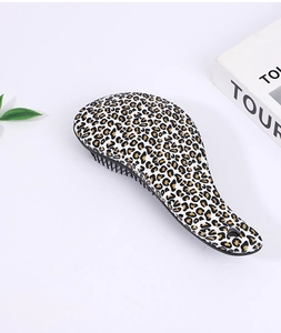 Close-up of leopard print detangling brush with black bristles and hanging hole
