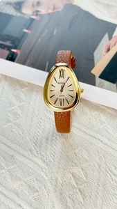 Detailed close-up of a gold water-drop snakehead watch with brown leather strap