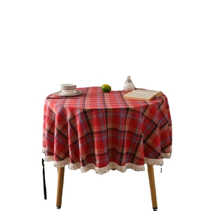 Classic red plaid round tablecloth with white tassels on a table with tea set