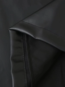 Close-up of black PU leather fabric texture and professional stitching on a short dress