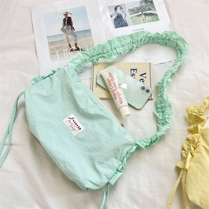 Vista dall'alto di borsa a tracolla in nylon plissettato verde menta con oggetti