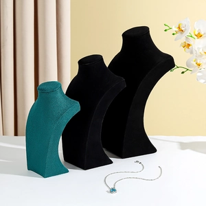 Three elegant velvet bust necklace displays in black and dark green for jewelry storage