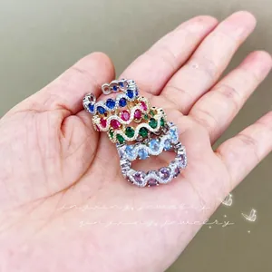 Close-up of stacked wavy gemstone rings with vibrant colorful zircon stones