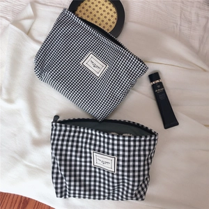 Detail of two-piece black and white gingham canvas makeup bags with Time to Party logo