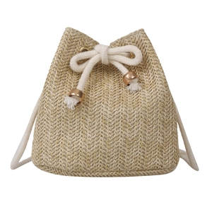 Handcrafted straw bucket bag with drawstring closure and gold beads on white background