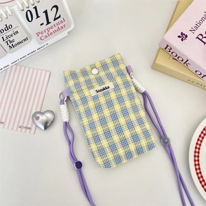 Close-up of yellow and blue plaid crossbody phone bag with purple adjustable strap