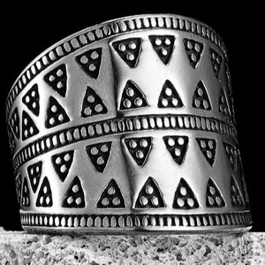 Minimalist stainless steel ring with triangular patterns on a stone base
