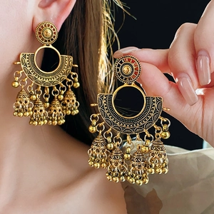 Macro detail of gold vintage Jhumka earrings with intricate fan pattern and bells