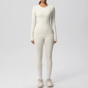 Vue de face d'un ensemble de yoga blanc crème avec haut à manches longues et legging