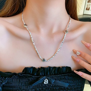 Silver square link necklace featuring three smiley face charms worn by a model