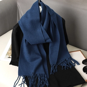 Close-up of deep blue cashmere-feel scarf featuring soft tassels and premium texture