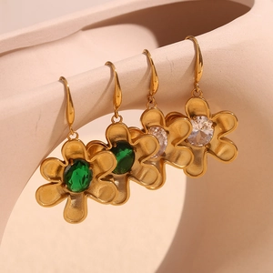 Macro detail of 18K gold plated floral drop earrings with green and white gemstones
