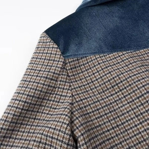 Détail du col en velours bleu cousu avec un tissu à motif pied-de-poule marron sur blazer