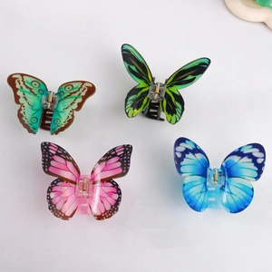 Set of four acrylic butterfly hair claws with colorful sky patterns on white background