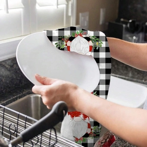 Close-up of Christmas gnome dish towel used for drying a white plate in kitchen