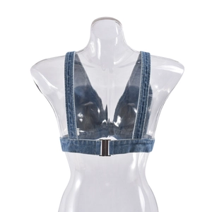Dettaglio della fibbia in metallo sul retro di un gilet in denim blu lavato corto