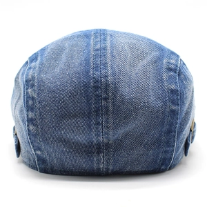 Dettaglio del berretto in denim lavato vintage con fibbia in metallo e cuciture a contrasto