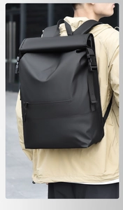 Detailed street shot of a large black roll-top waterproof backpack for urban commuting
