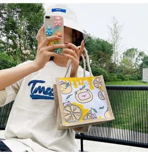 Detail of canvas tote bag featuring cute cartoon bear and lemon prints in outdoor use