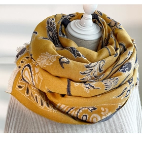Detail of yellow cashmere-feel scarf with blue leaf patterns and delicate tassel edges