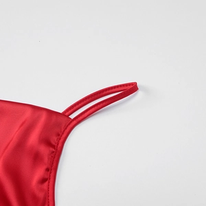 Close-up of red satin dress with thin straps and smooth silk-like texture detail