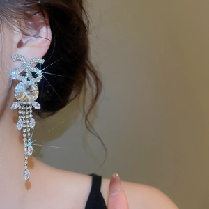 Gros plan de boucles d'oreilles pampilles en argent avec strass sur un modèle féminin