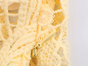 Detail of yellow lace fabric texture with matching invisible zipper on elegant set