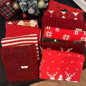 Flat lay of retro colorful striped shawls with Christmas patterns like reindeer and snowflakes
