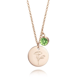 Close-up of rose gold birthday necklace with poppy flower pendant and green gemstone