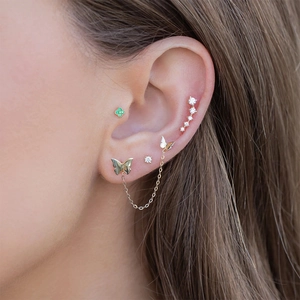 Detail of S925 silver butterfly tassel earrings and ear crawlers worn on ear