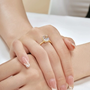 Detail of s925 silver ring in gold finish with emerald cut cubic zirconia on a hand