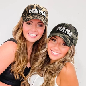 Detail of leopard and camo baseball caps featuring white plush MAMA embroidery