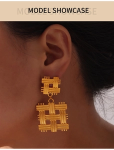 Detail view of gold geometric woven mesh square earrings on model with high gloss finish