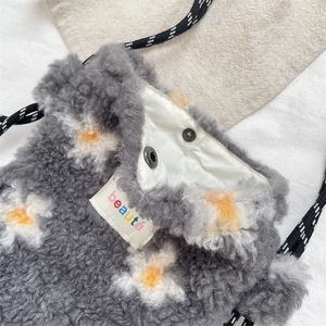 Detail of plush lamb fleece bag with yellow flower embroidery and silver snap closure