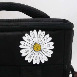 Detail of daisy mood wheel pin on black backpack with yes and no decision options