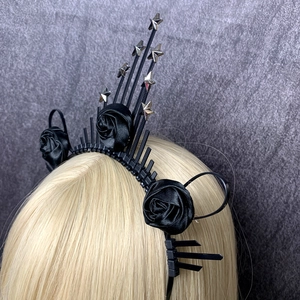 Detail of gothic halo crown featuring black spikes, cloth roses and silver star studs