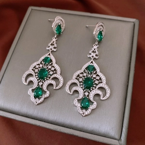 Détail de boucles d'oreilles vintage en argent avec pierres vertes et zircons brillants