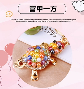 Detailed macro of golden turtle keychain featuring colorful pearls and sparkling crystals