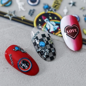 5D embossed space astronaut and heart nail stickers applied on red and white manicure