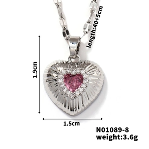 Detail view of heart pendant with pink zircon and size labels 1.9cm by 1.5cm