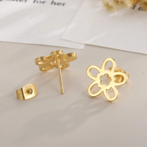 Detailed macro view of gold hollow flower earrings with matching backings for women